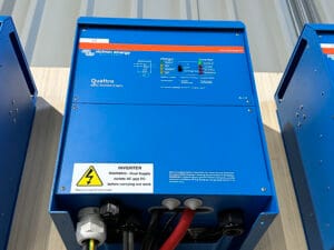 Blue Victron Energy Quattro inverter on table.