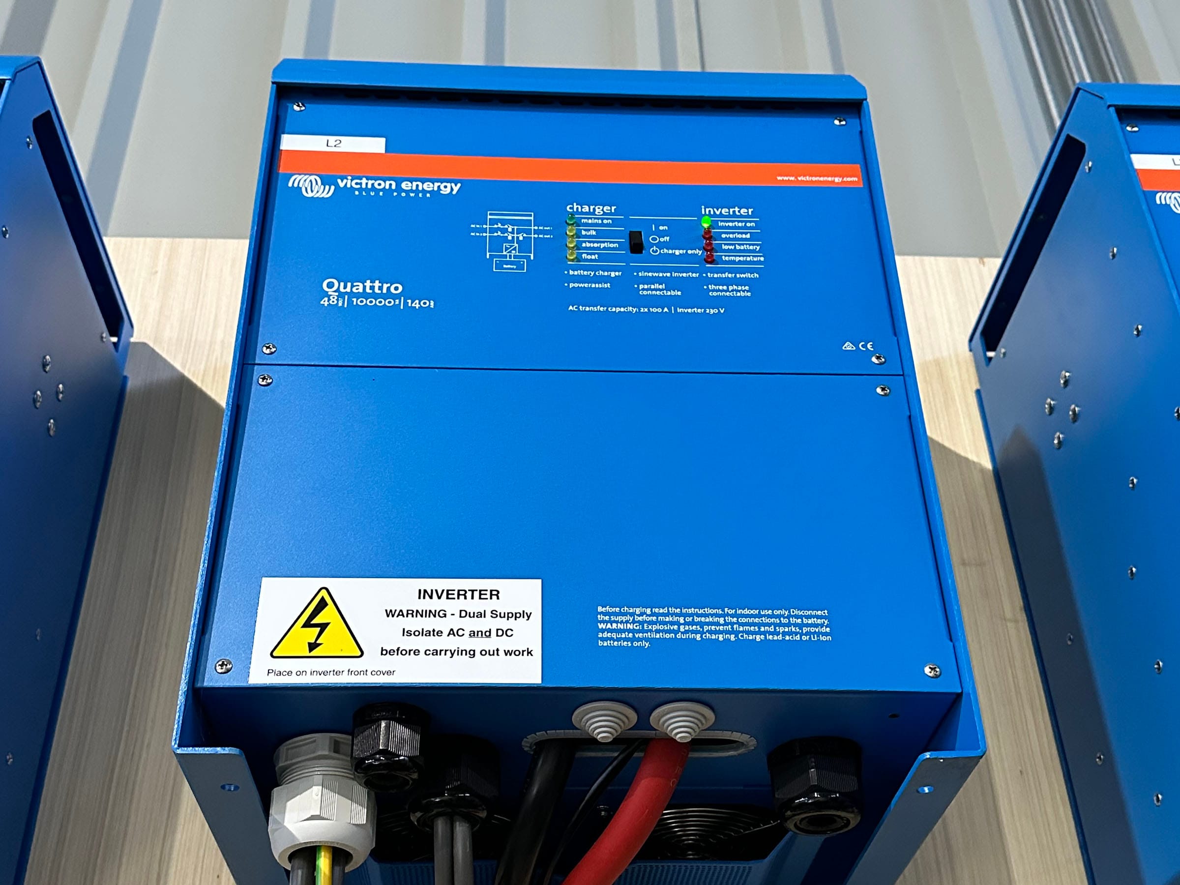 Blue Victron Energy Quattro inverter on table.