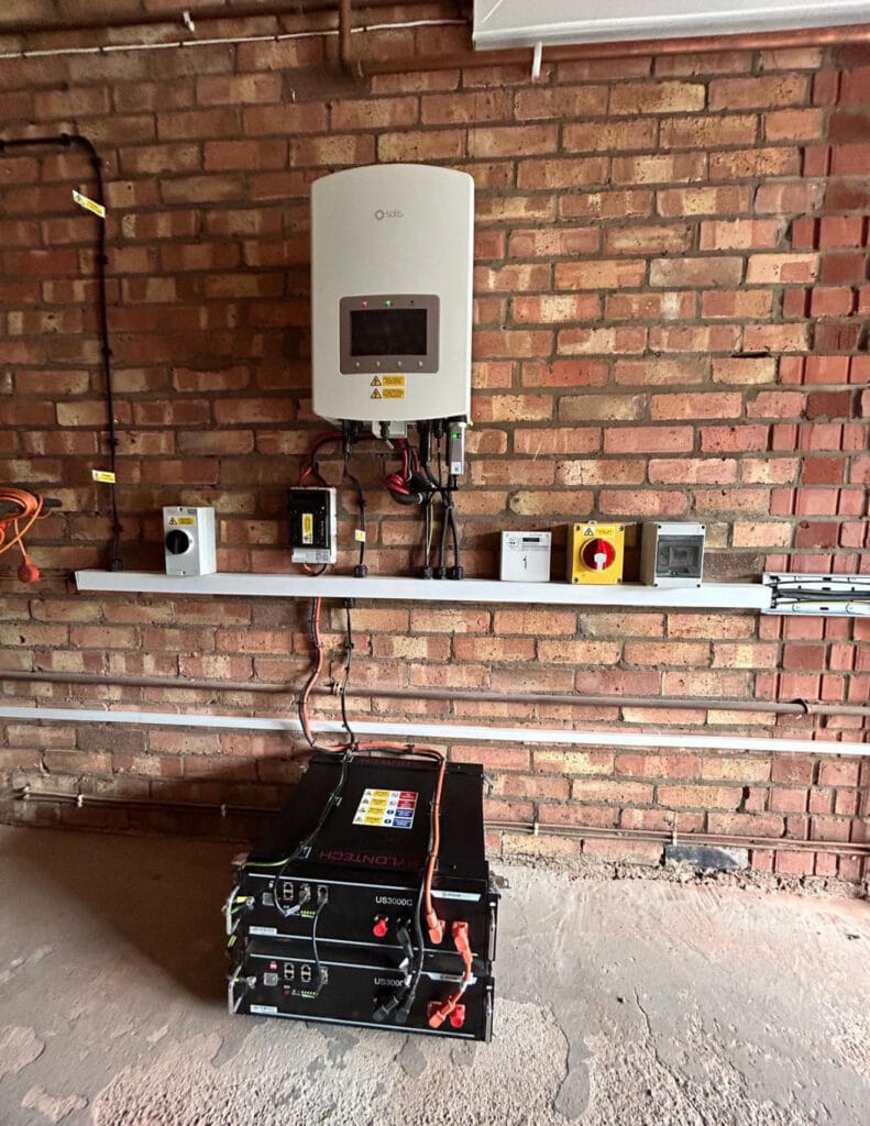 Wall-mounted inverter and batteries in utility room.