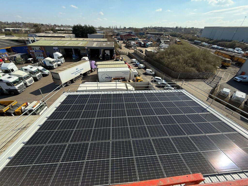 Solar panels on rooftop overlooking industrial area.