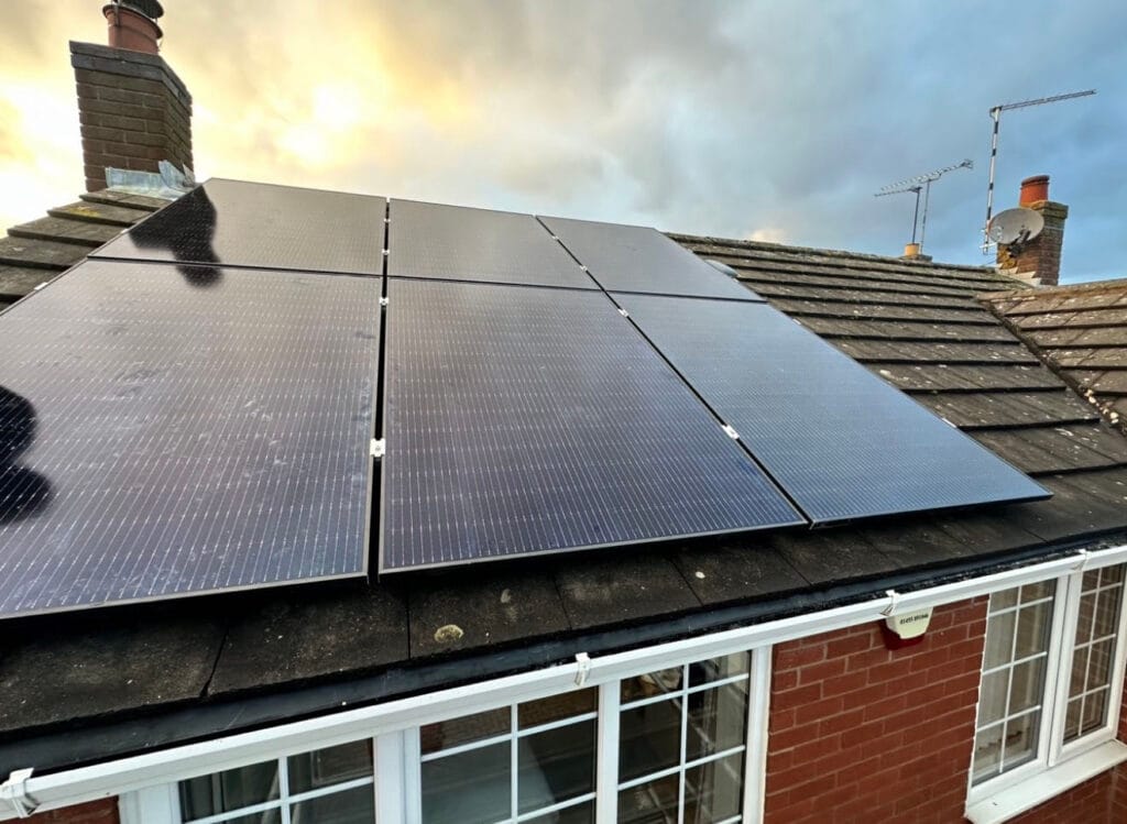 Solar panels on a house roof at sunrise.