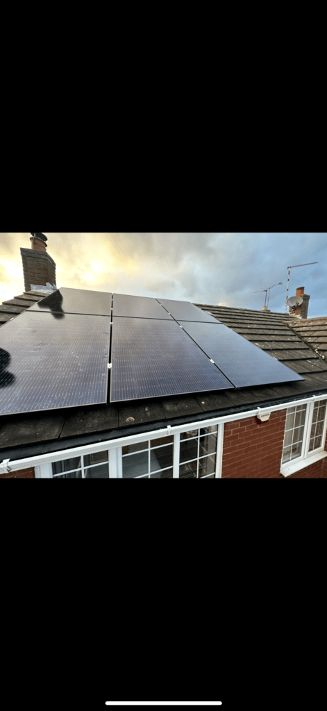 Solar panels on house roof at sunset.