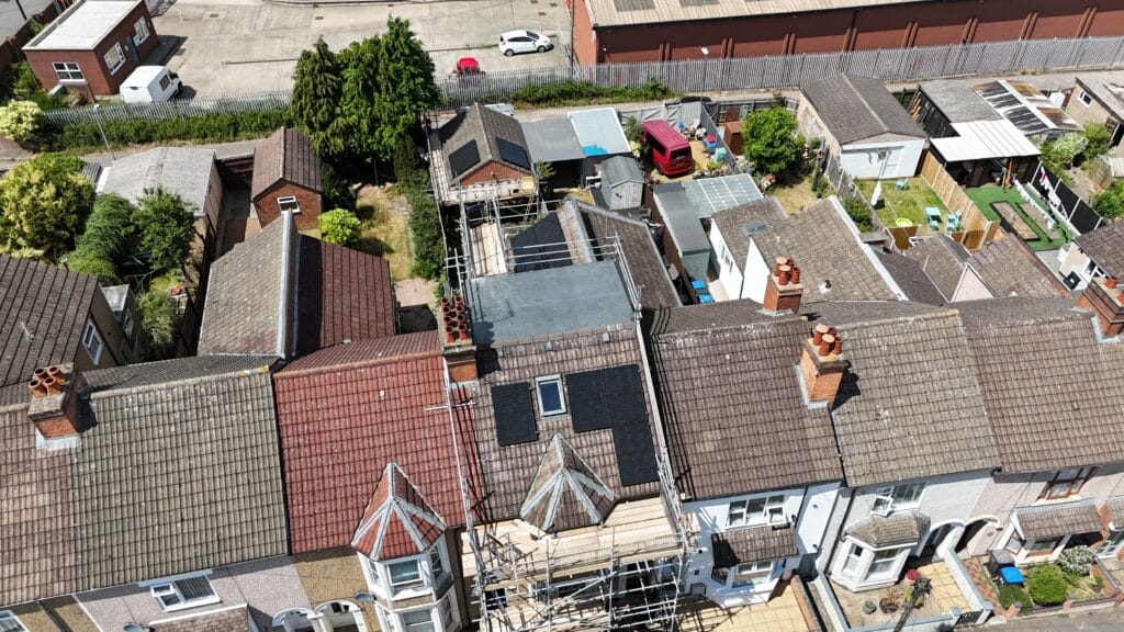 Aerial view of residential rooftops with scaffolding.