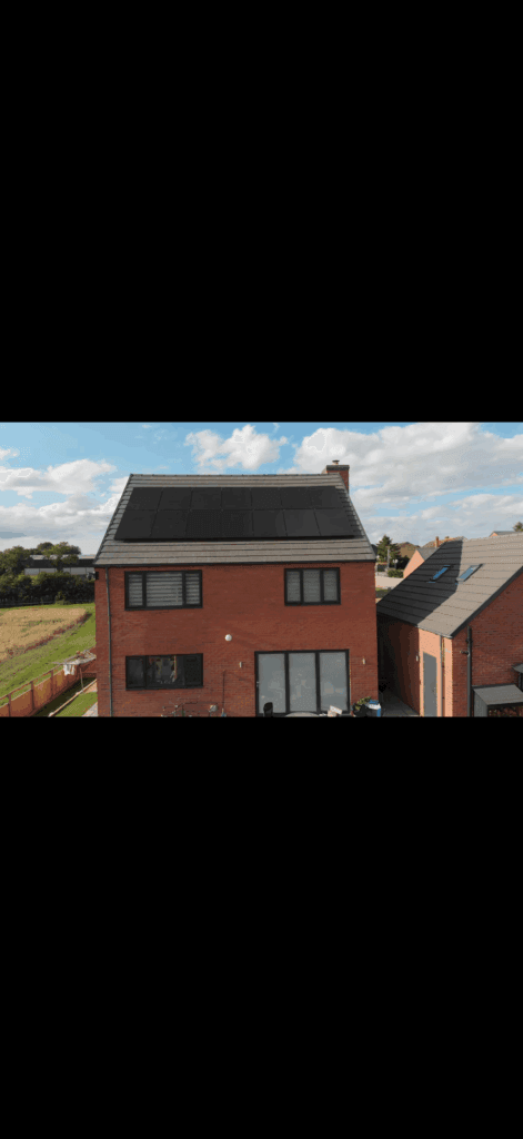 Brick house with solar panels under blue sky.