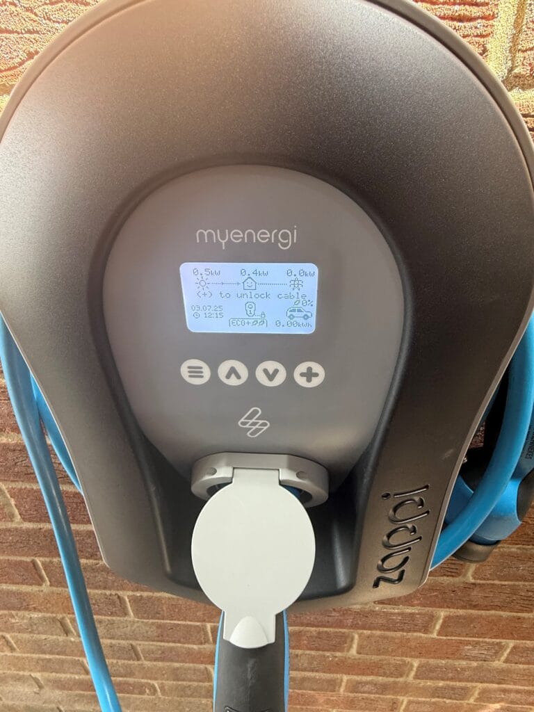 Myenergi electric car charger on brick wall.