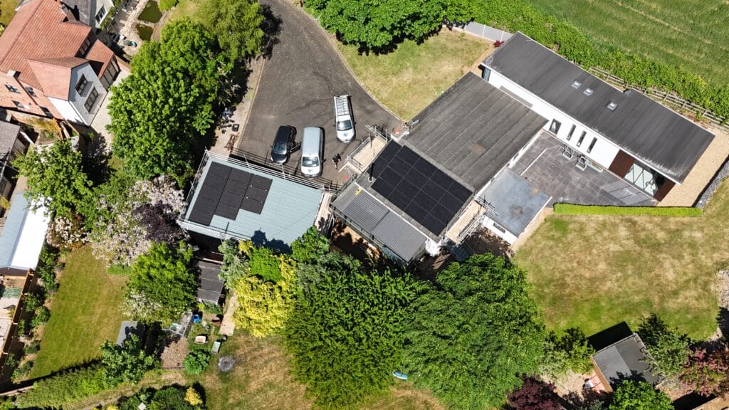 Aerial view of buildings with solar panels and gardens.