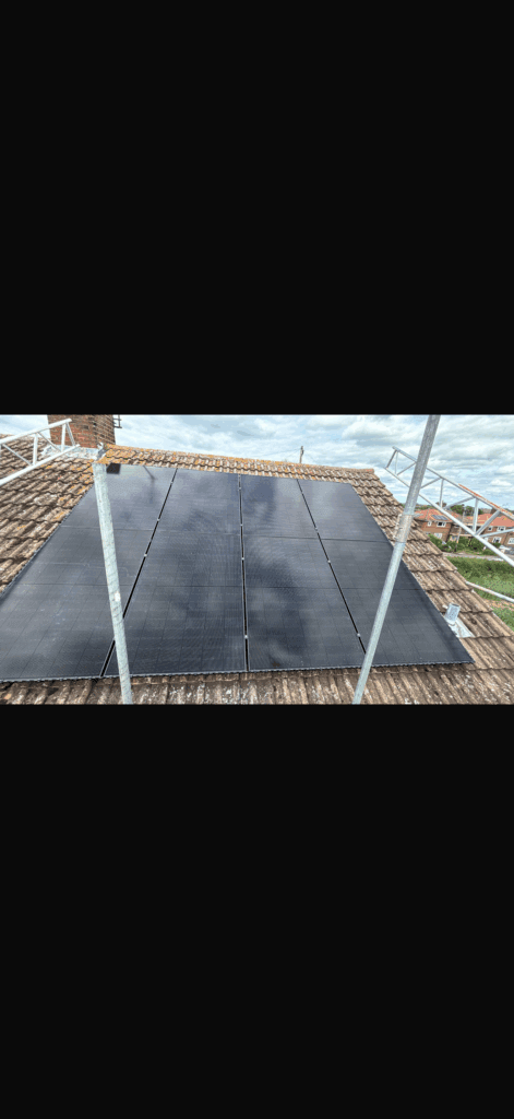 Solar panels on a tiled roof under scaffolding.