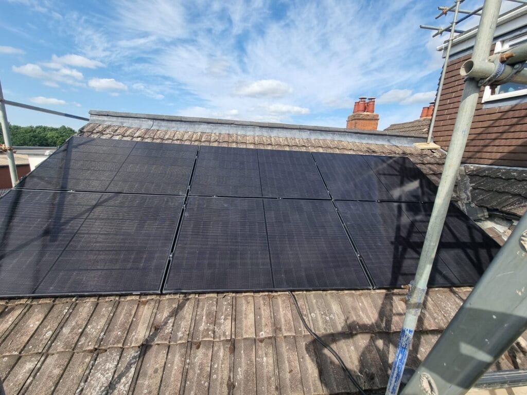 Solar panels installed on rooftop under blue sky.
