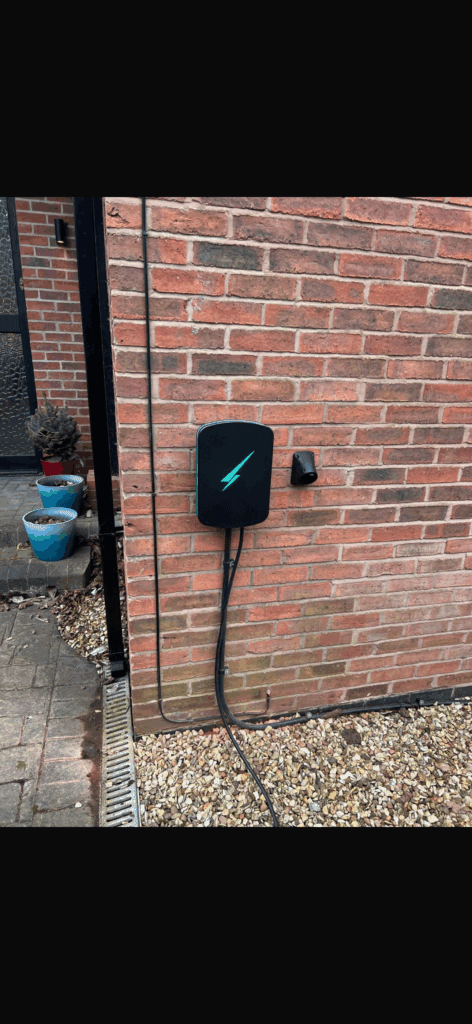Electric vehicle charger mounted on brick wall
