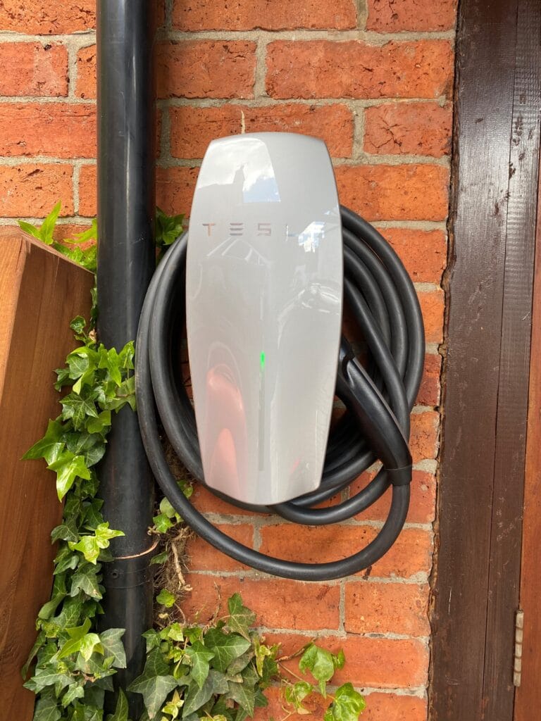Electric car charger mounted on brick wall